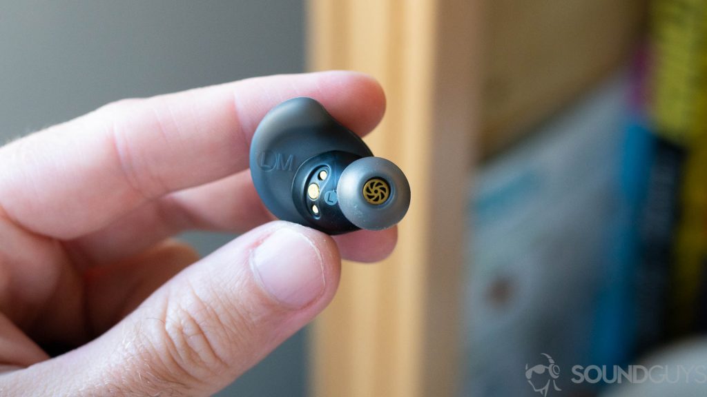 Man holding Anker Soundcore Spirit Dot 2 with ear tip and drivers visible.