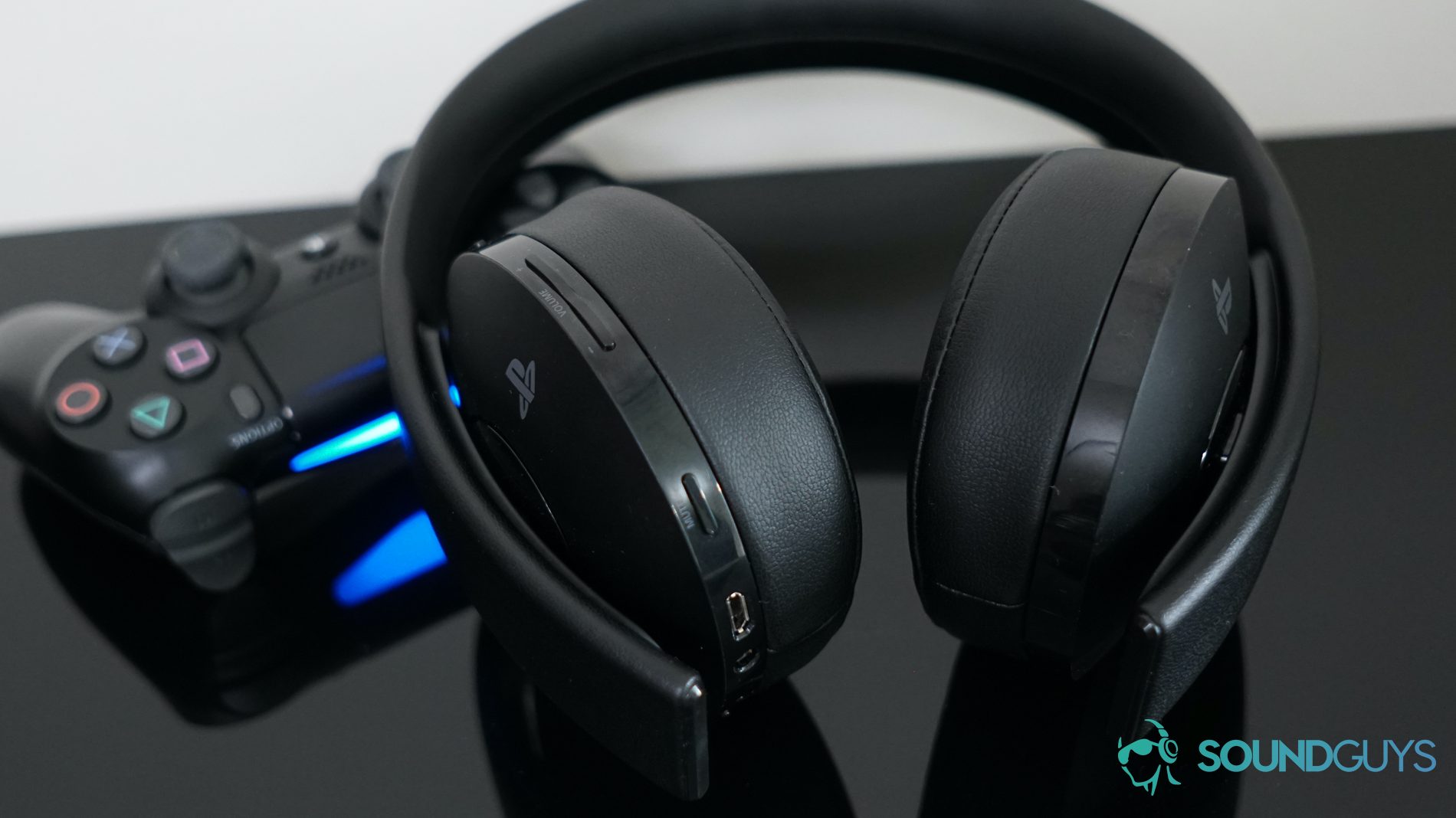 Playstation Gold Wireless Headset PS4 controller shot Playstation Gold Wireless Headset leans on a Playstation 4 controller