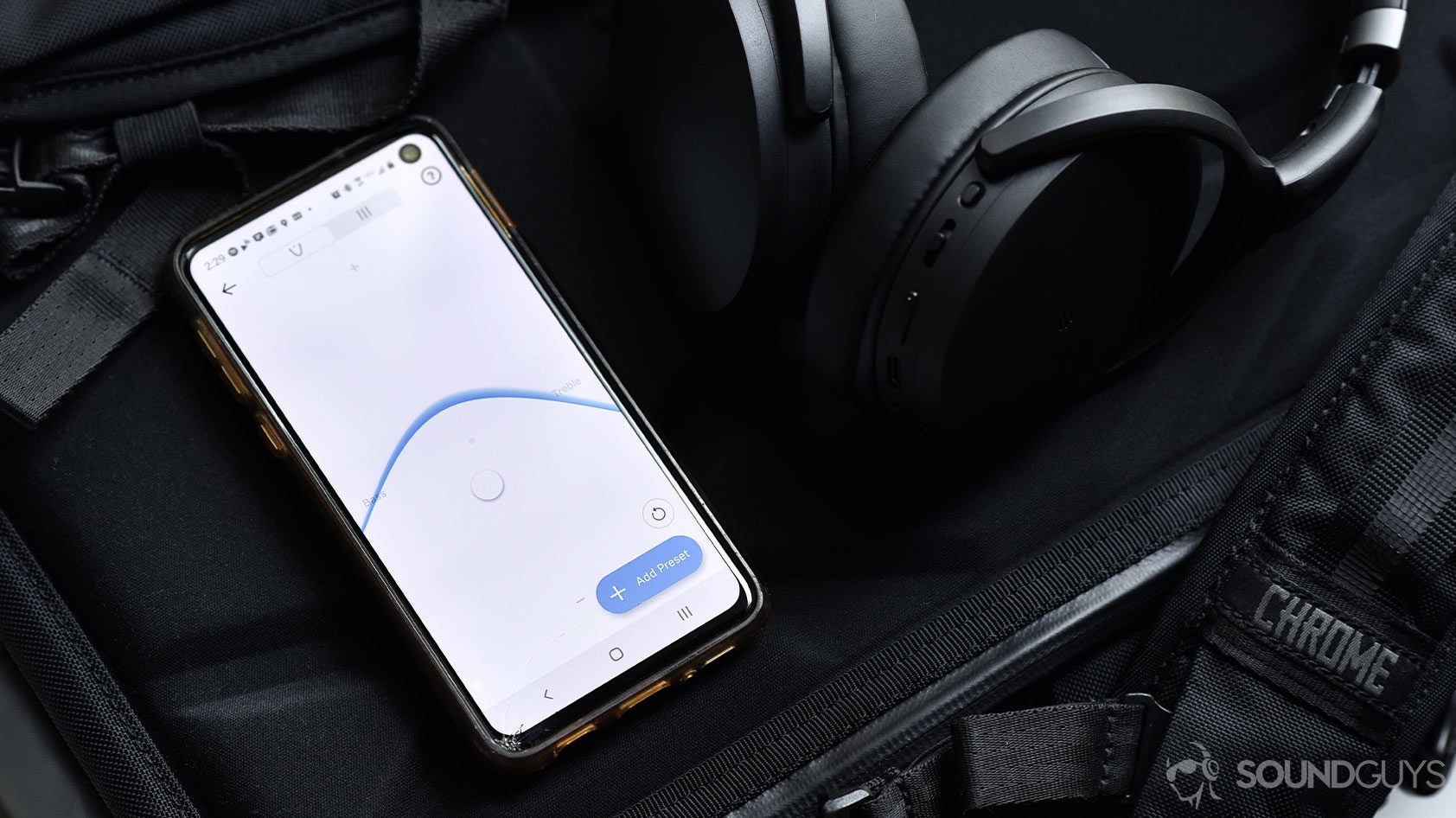 A picture of the Sennheiser HD 450BT noise canceling headphones next to a Samsung Galaxy S10e smartphone with the Sennheiser app and EQ on display.
