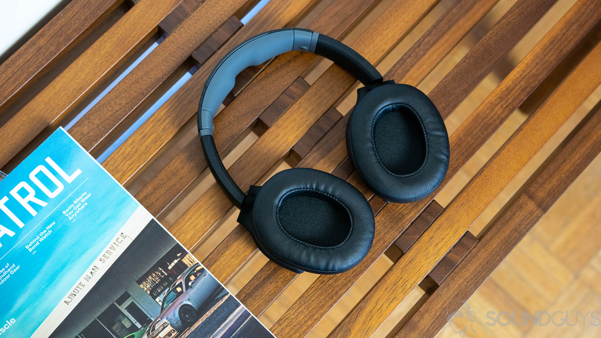 Skullcandy Crusher Evo earcups The Skullcandy Crusher Evo lying flat on a wooden bench next to magazines.