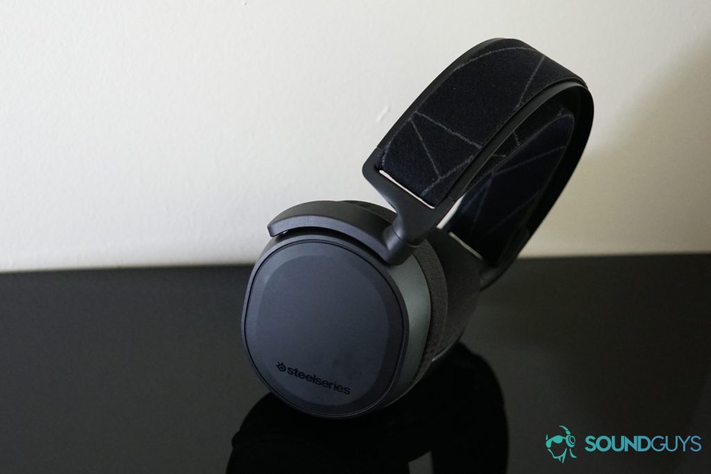 The SteelSeries Arctis 7 Wireless stands on a black reflective surface.