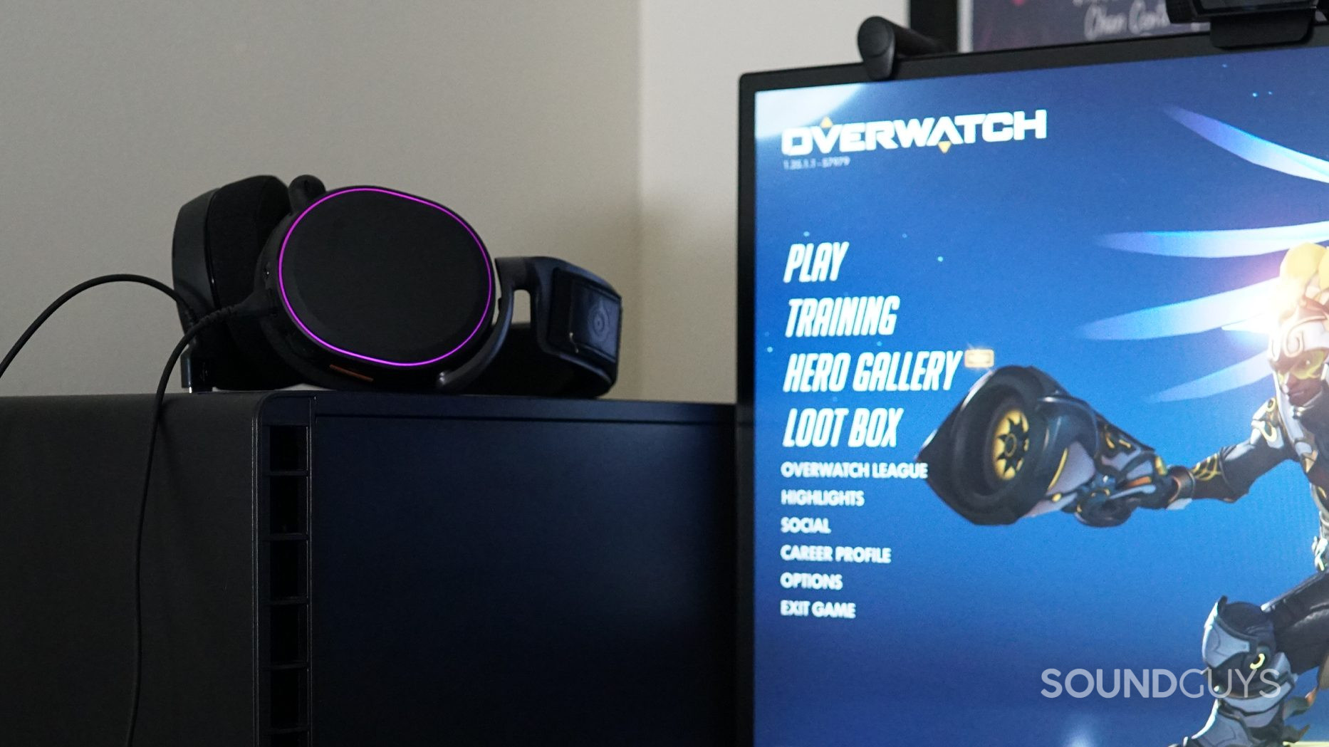 The Arctis Pro gaming headset sits on a desktop PC tower running Overwatch.