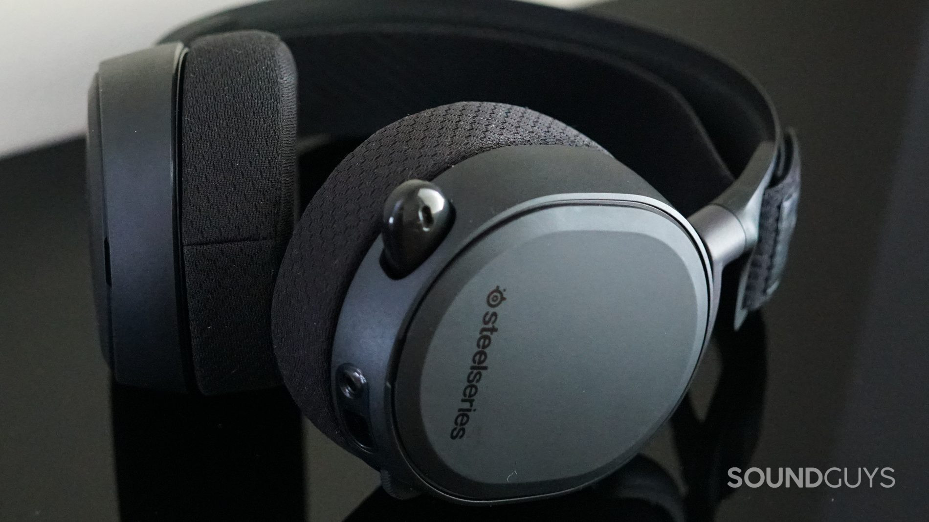 The SteelSeries Arctis Pro + GameDAC headset in black against a black reflective surface.