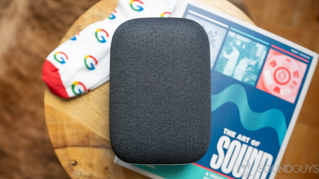 Google Nest Audio on top of coffeetable with a book and pair of Google socks