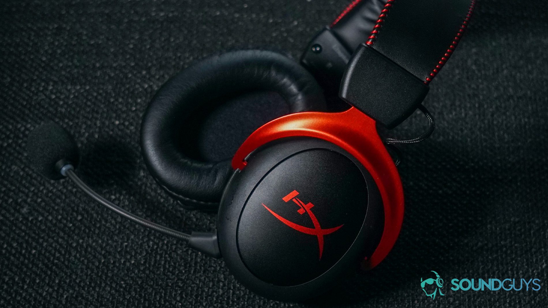 The HyperX Cloud II Wireless gaming headset lays on a fabric surface.