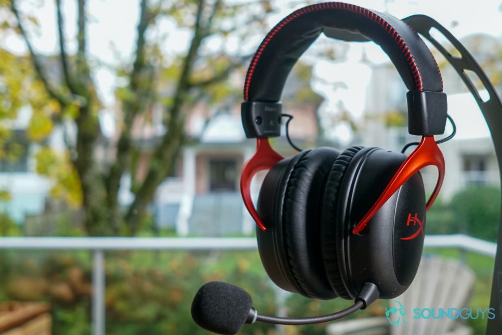 The HyperX Cloud II Wireless hangs from a stand in front of a window