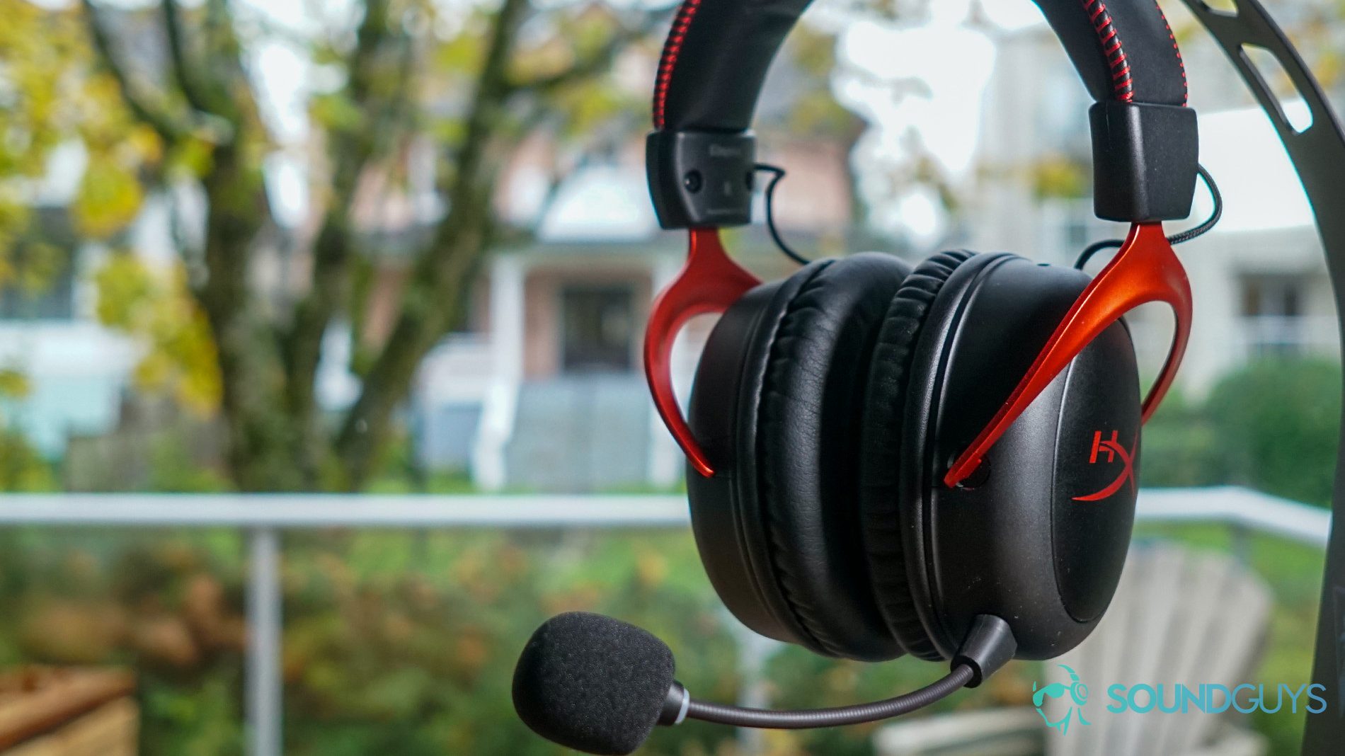 The HyperX Cloud II Wireless hangs from a stand in front of a window