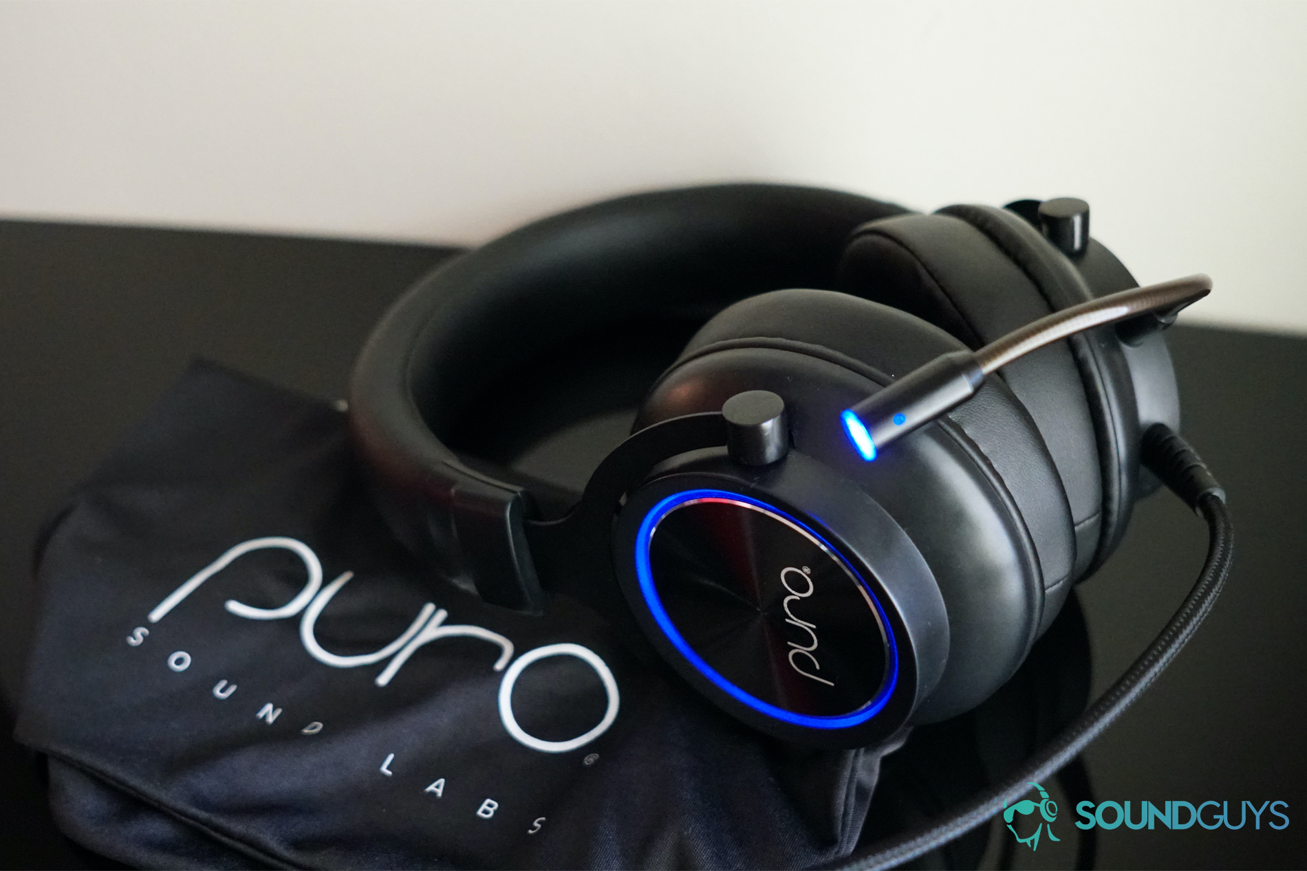 The Puro Sound Labs PuroGamer headset sits on top of its carry bag on a black surface