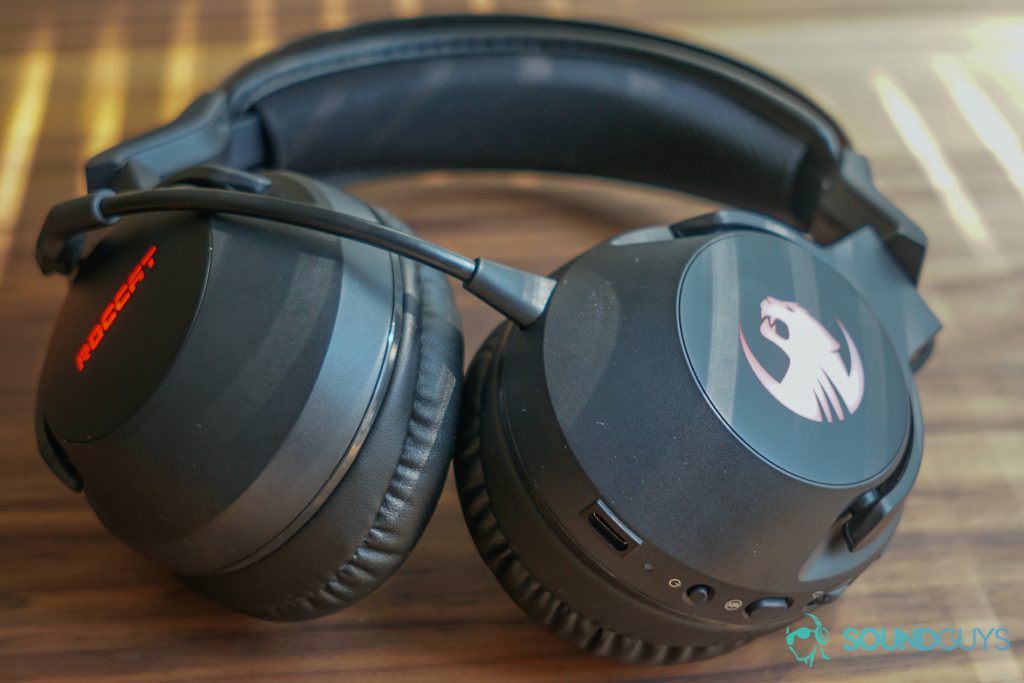 The Roccat Elo 7.1 Air sits on a wooden table next to some shut blinds.