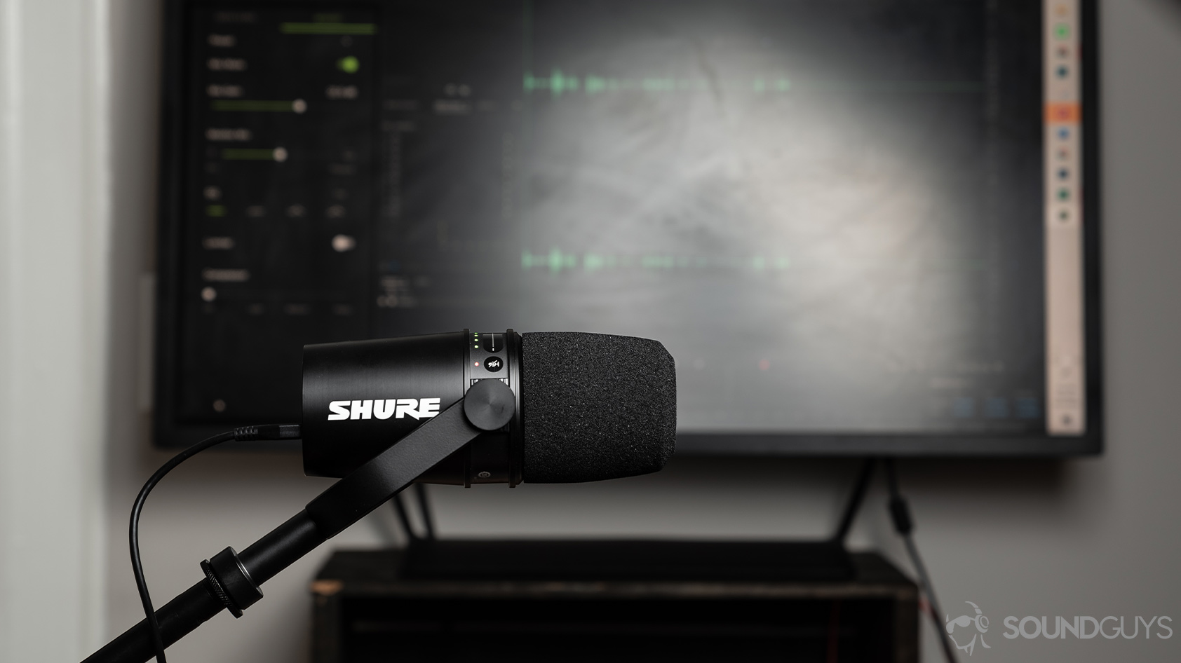 The Shure MV7 USB microphone in front of a computer monitor with Adobe Audition in use.