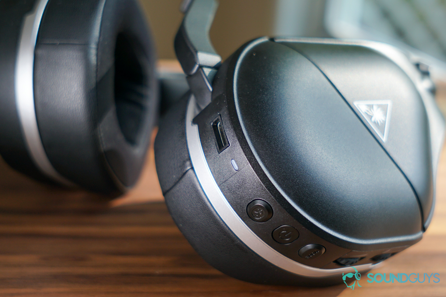The Turtle Beach Stealth 700 Gen 2 lays on a table with its buttons and charging port in focus.