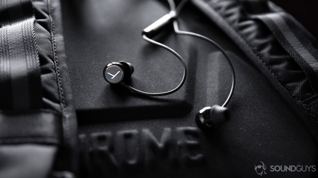 The Beyerdynamic Soul Byrd wired earbuds in black against the backrest of a black backpack.