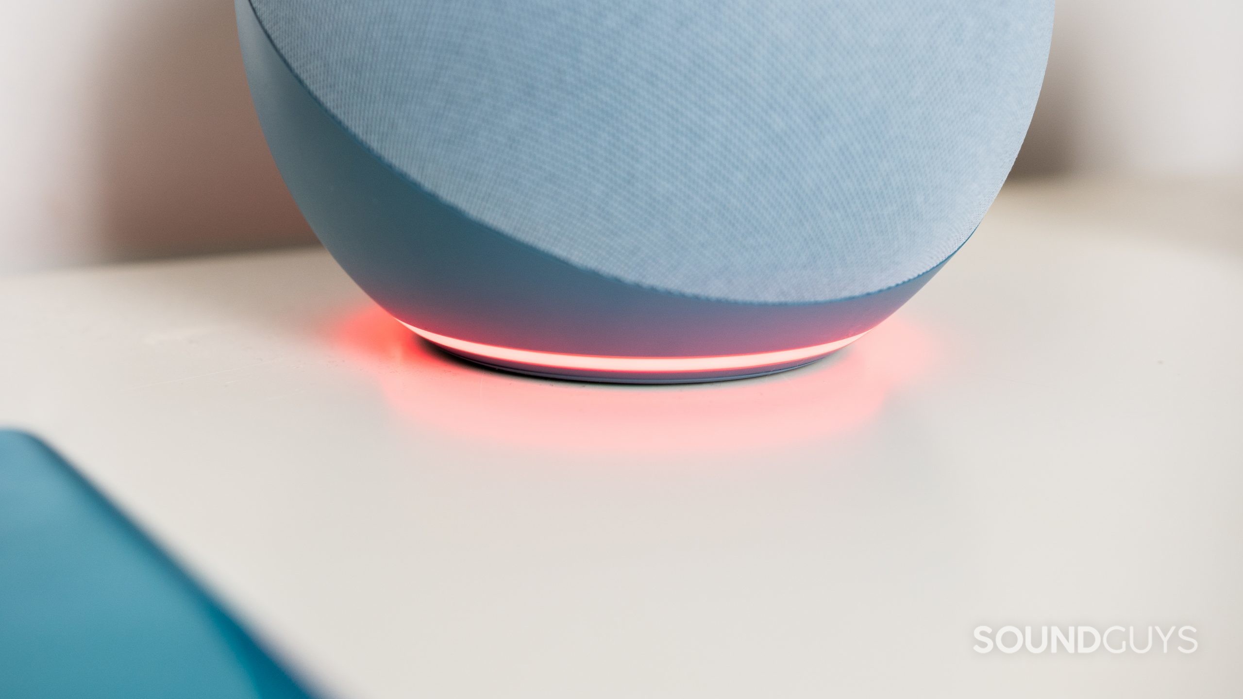 The ring of the Amazon Echo 4th gen glowing red on a white table.