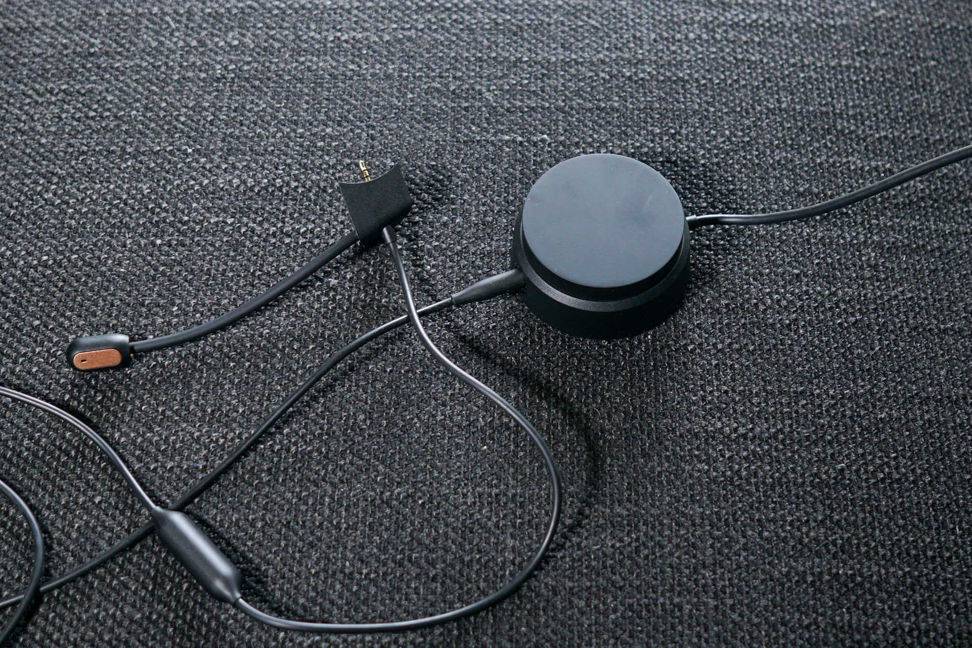 The detachable microphone and volume dial for the Bose QuietComfort 35 II gaming headset sit together on a fabric surface.
