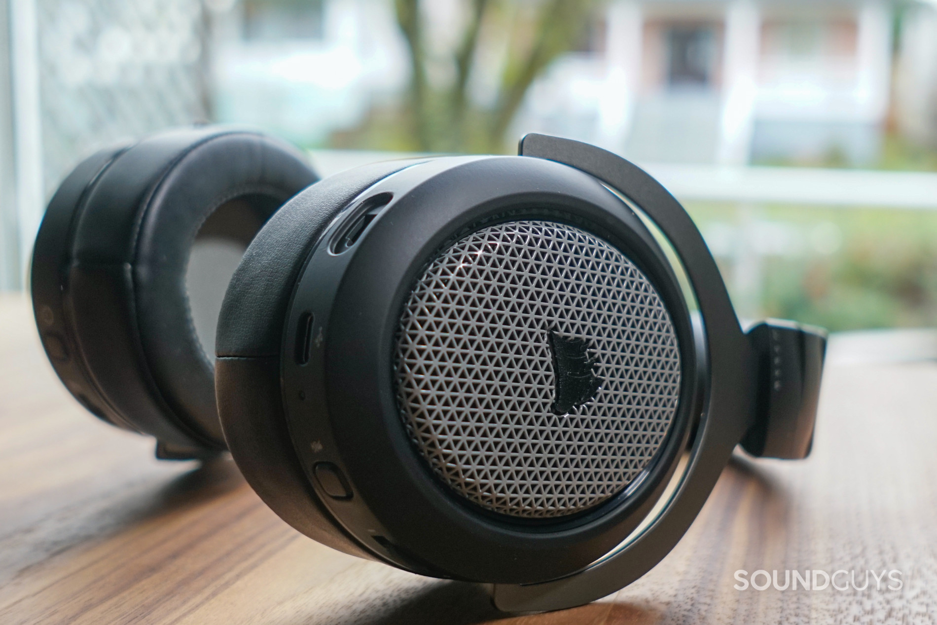 The Corsair HS75 XB Wireless lays on a table with its mic unplugged and controls visible.