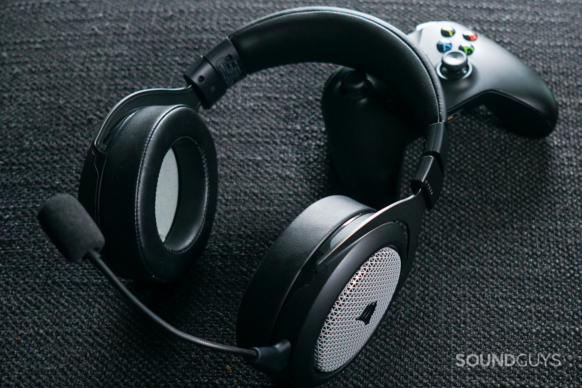 Corsair HS75 XB Wireless gaming shot The Corsair HS75 XB Wireless lays on top of an Xbox One controller, on a fabric surface.