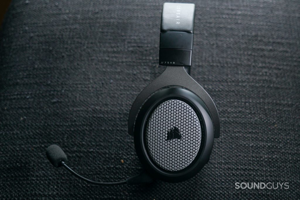 The Corsair HS75 XB Wireless lays on its side on a fabric surface