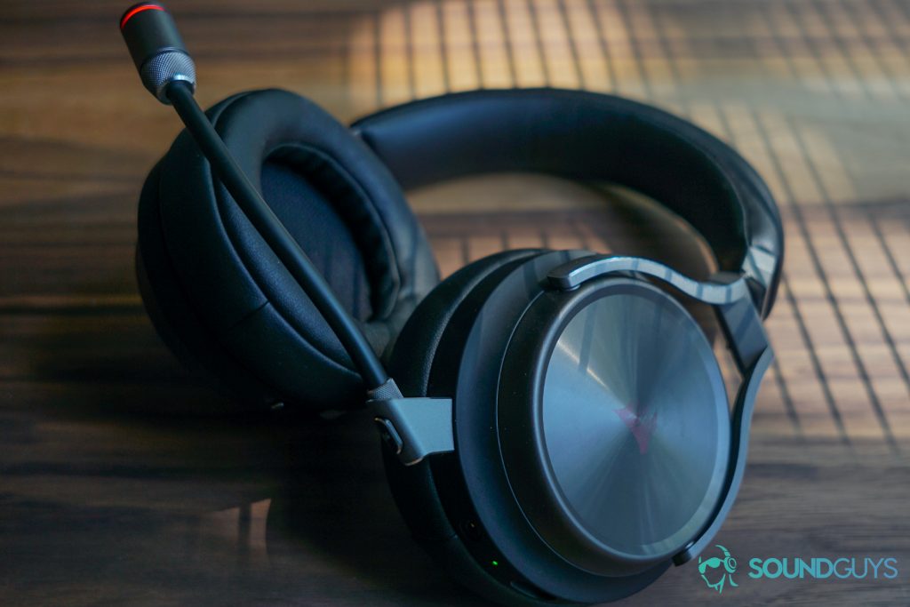 The Corsair Virtuoso Wireless SE sits on a wooden table with sunlight shining through blinds on it.