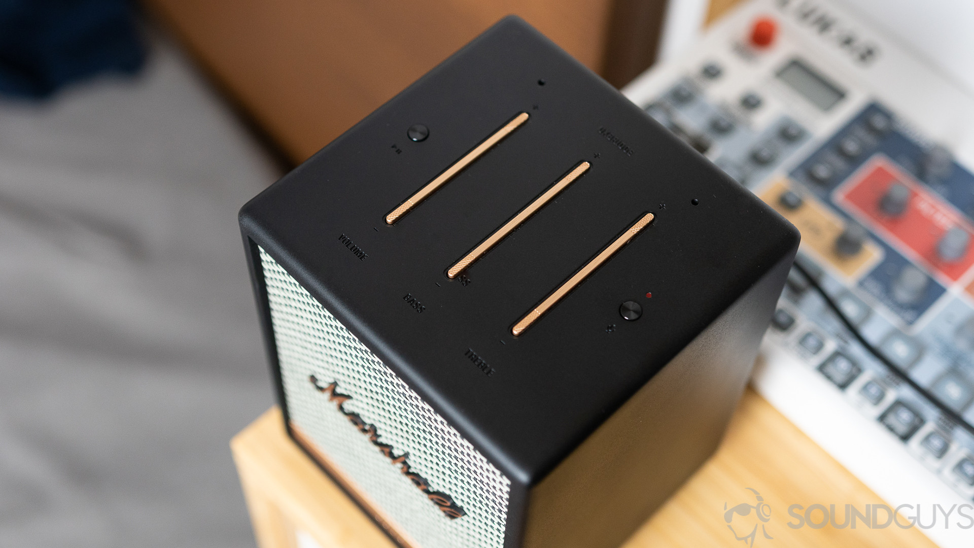 The top of the Marshall Uxbridge Voice speaker on a table with a synth in the background