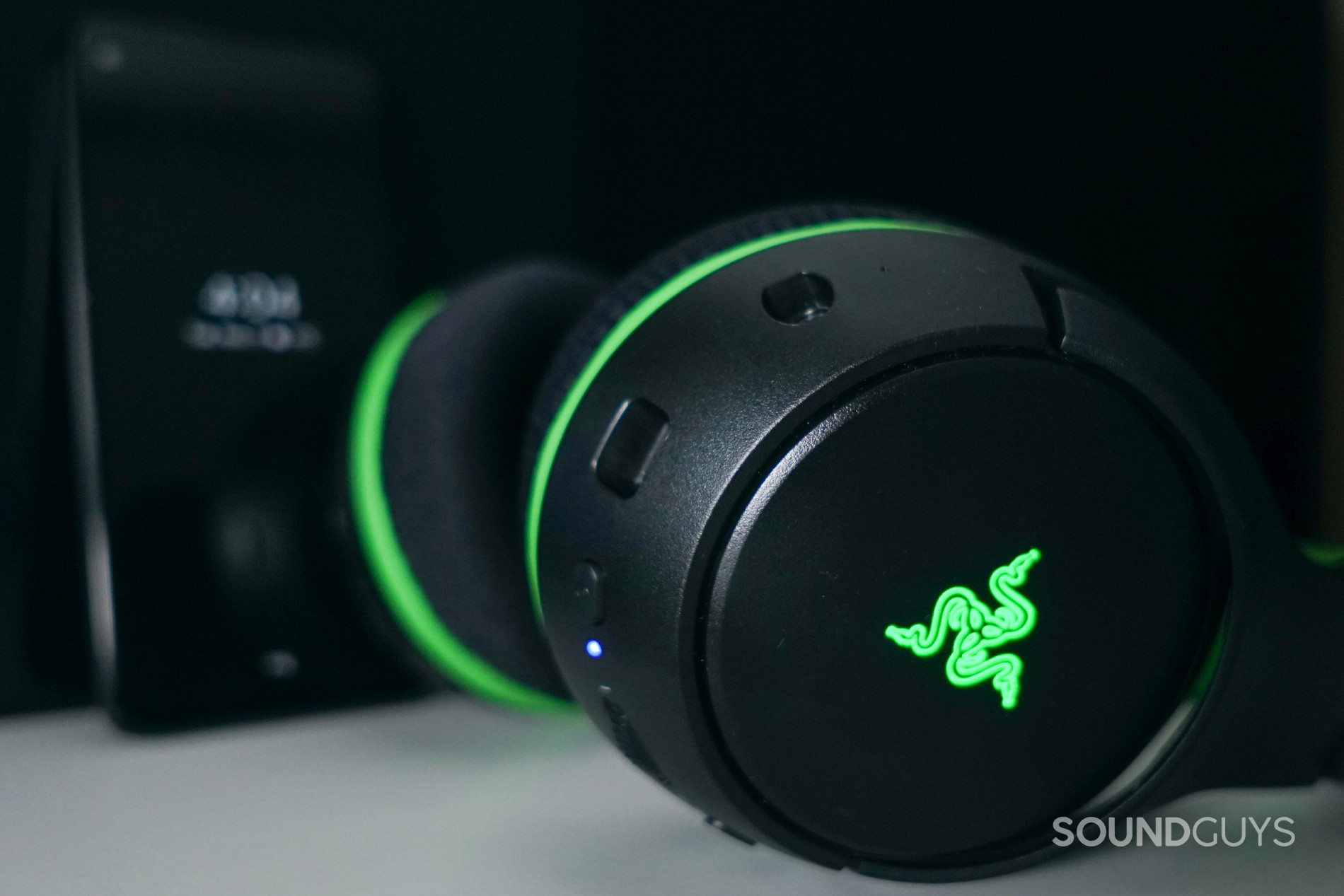 The Razer Kaira Pro gaming headset sits on a shelf in front of a Google Pixel 4a.