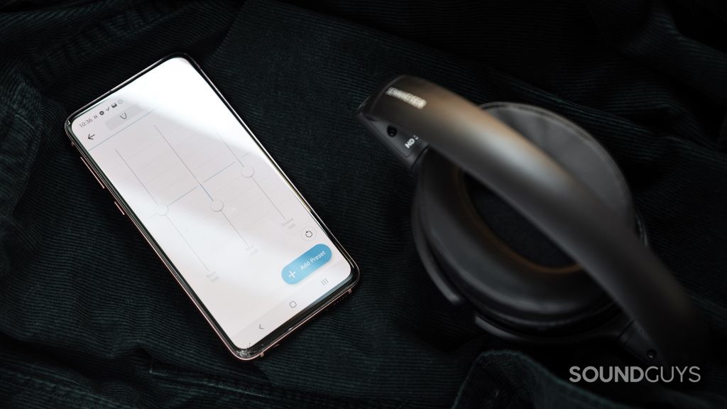 The Sennheiser HD 350BT Bluetooth headphones folded next to a Samsung Galaxy S10e with the Sennheiser Smart Control app with the custom EQ module open.