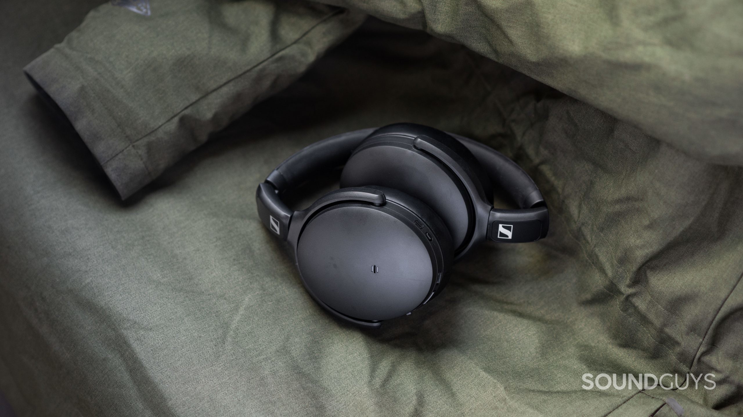 The Sennheiser HD 350BT Bluetooth headphones balled up on top of a green winter coat.