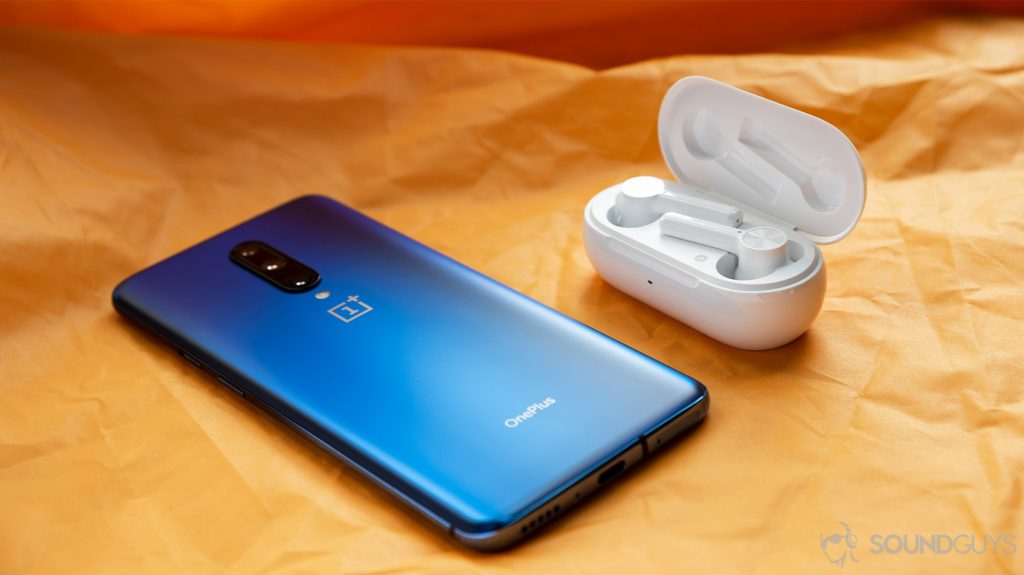 The OnePlus Buds Z cheap true wireless earbuds in the open charging case next to a OnePlus 7 Pro smartphone in blue.