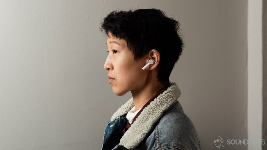 A woman wears the OnePlus Buds Z cheap true wireless earbuds in white to illustrate the buds' sizing.