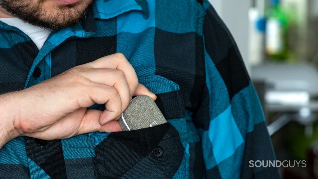A bearded man places the Sennheiser Momentum True Wireless 2.0 earphones into his left breast pocket.