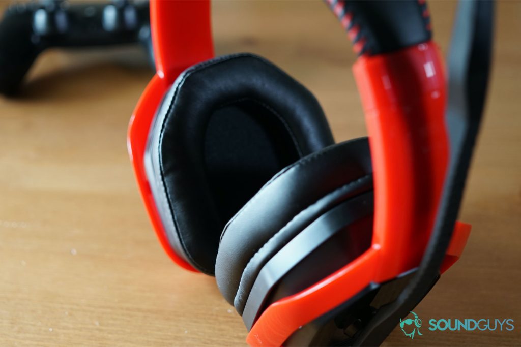 The AmazonBasics Pro Gaming headset standing up on a wooden table with a Playstation 4 controller in the background.