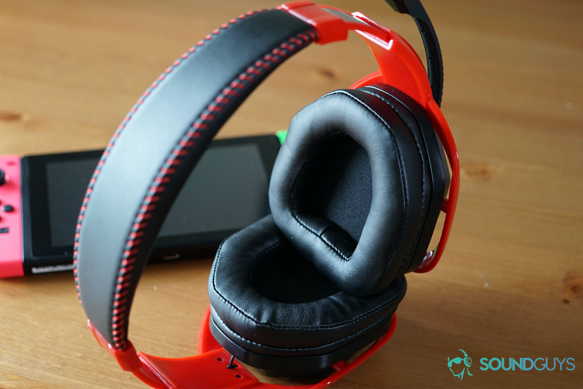 The AmazonBasics Pro Gaming Headset lying on it's side next to a Nintendo Switch on a wooden table.