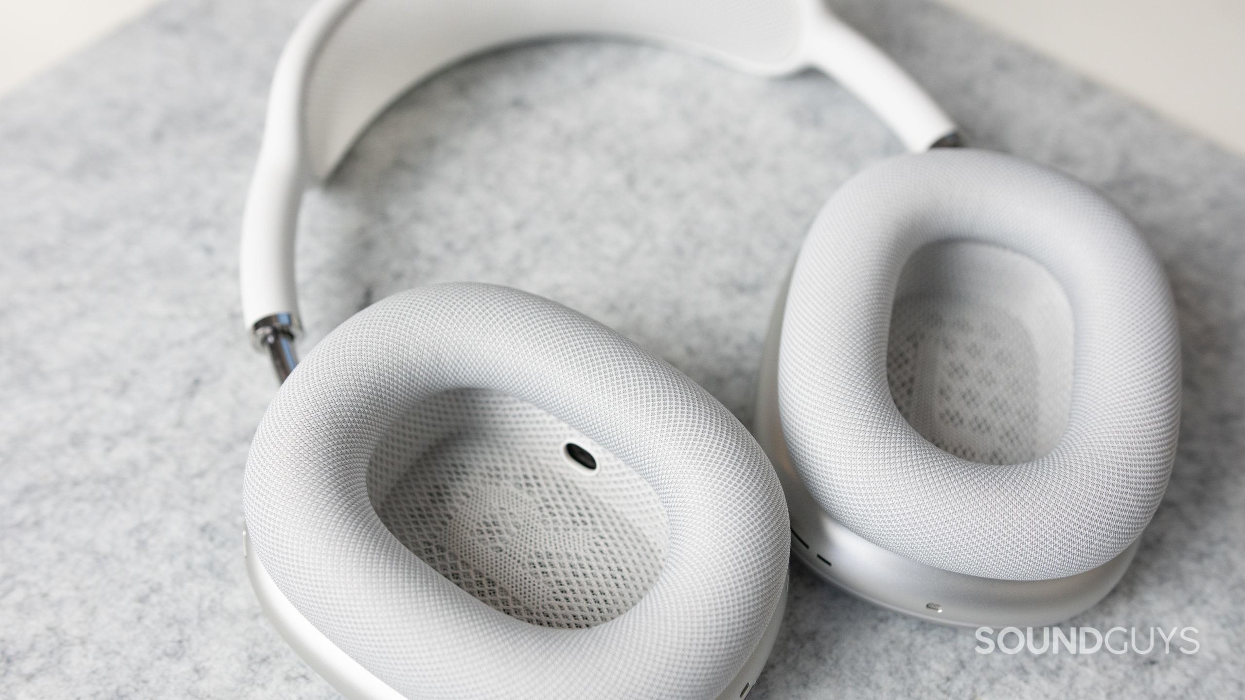 The Apple AirPods Max in white on a gray felt deskmat.