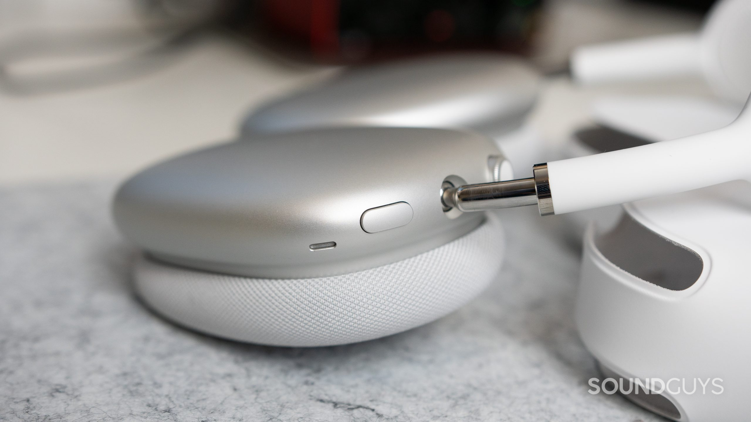 Close-up of the noise canceling toggle on the Apple AirPods Max as it is on a desk.