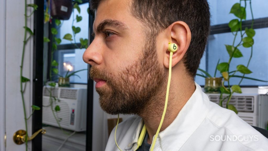 Profile shot of man in white shirt wearing yellow Beats Flex.