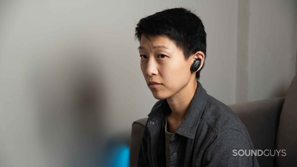 A woman wears the Bose QuietComfort Earbuds noise cancelling true wireless earbuds.