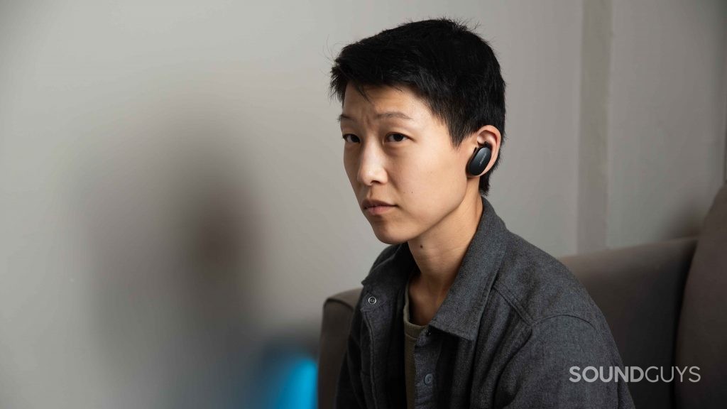 A woman wears the Bose QuietComfort Earbuds noise canceling true wireless earbuds.