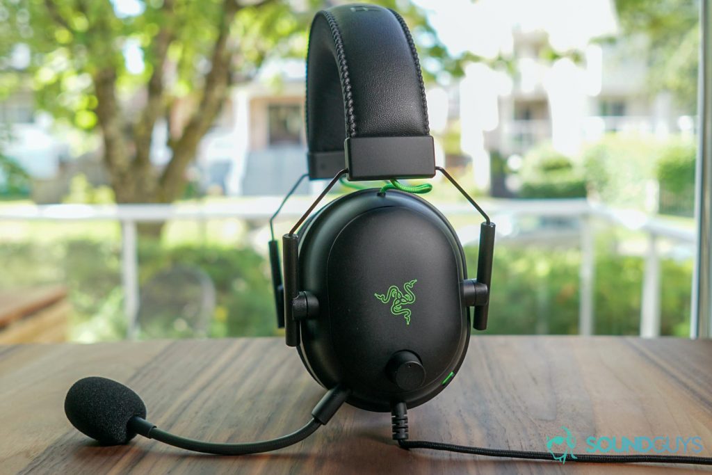 The Razer BlackShark V2 gaming headset sits on table in front of a window.