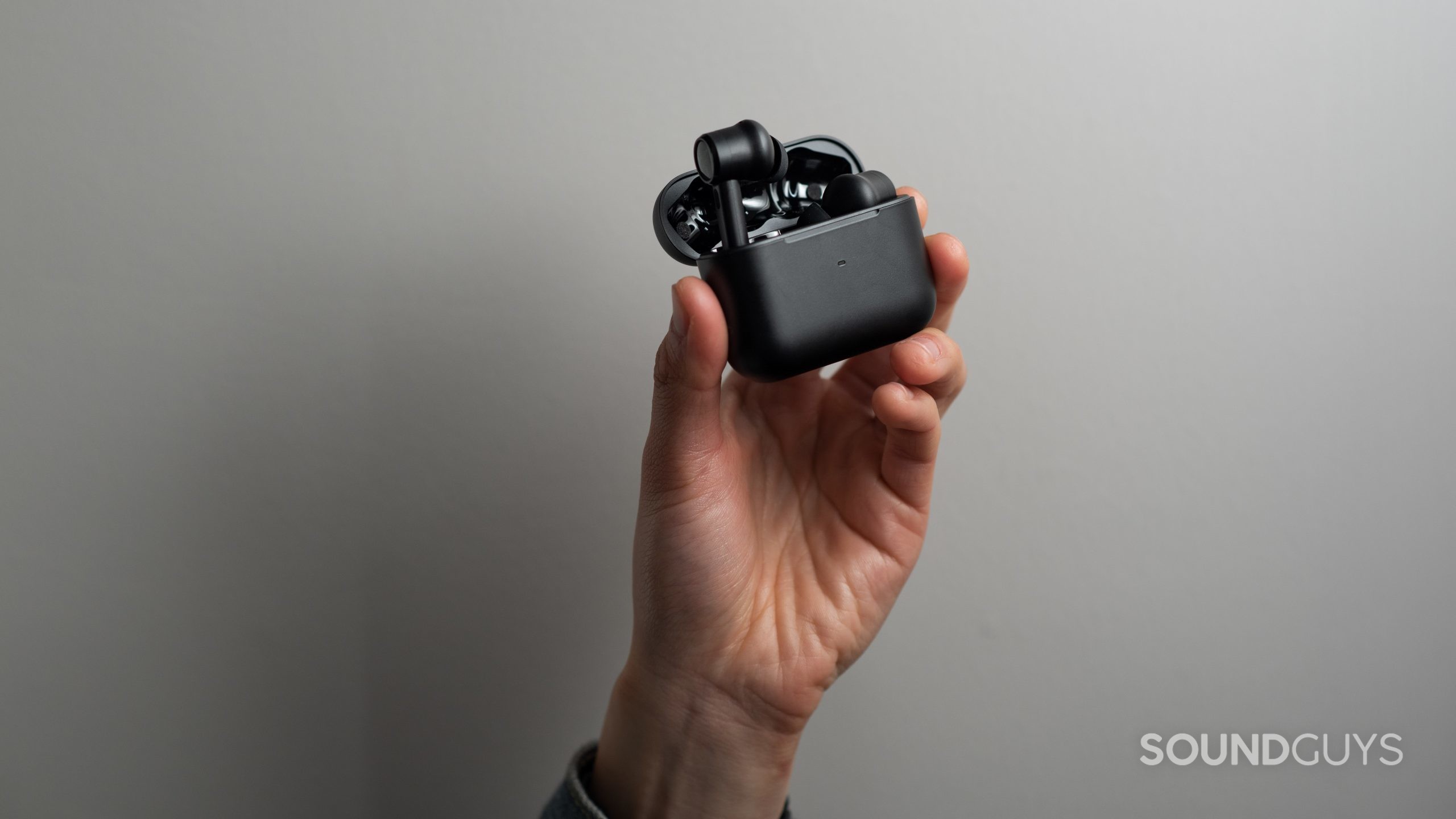 Razer Hammerhead True Wireless Pro-5 A hand holds the Razer Hammerhead True Wireless Pro noise canceling earbuds in the case.