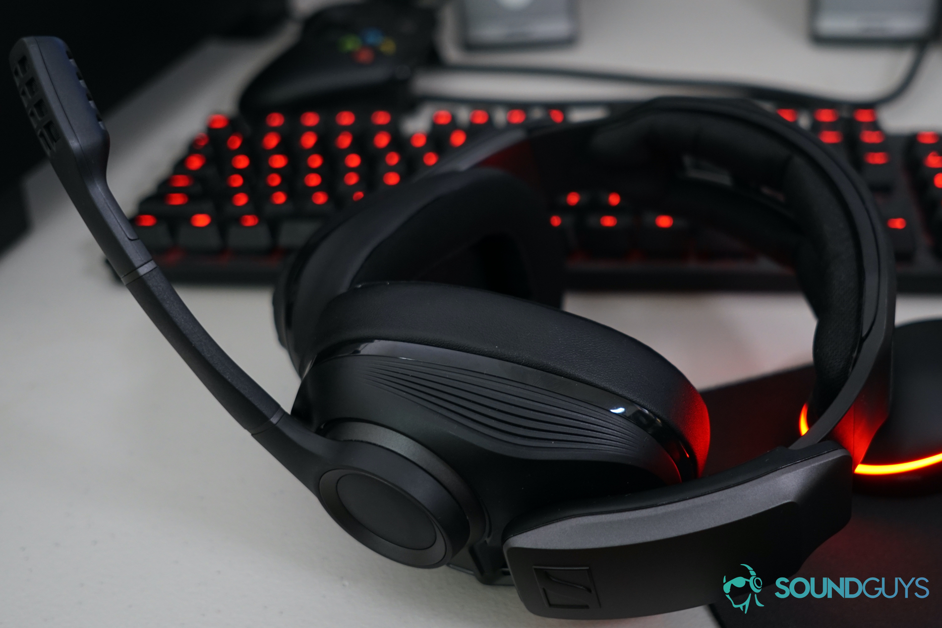 The Sennheiser GSP 670 gaming headset sits on a desk in front of a Logitech gaming mouse and keyboard