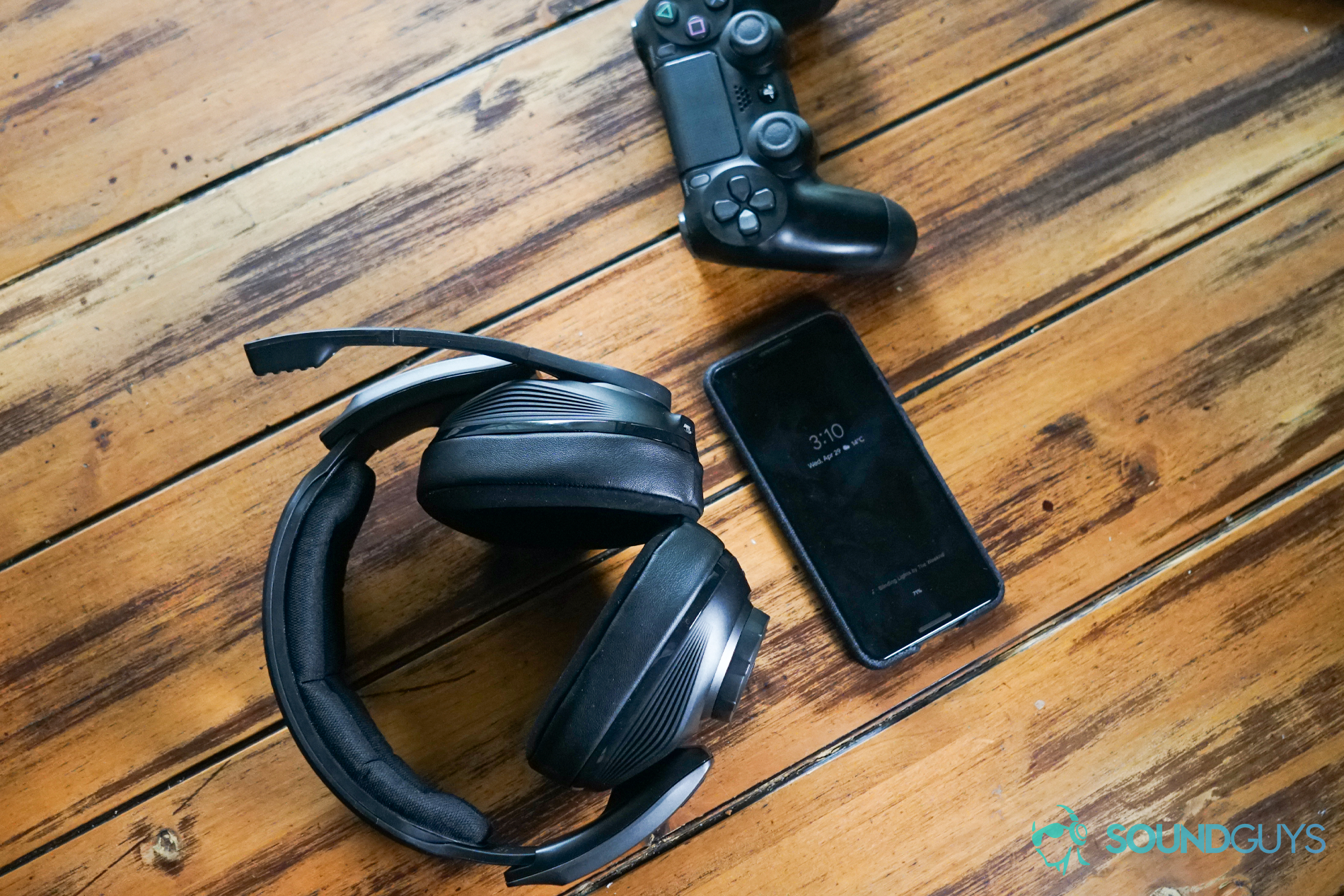 The Sennheiser GSP 670 lays on a table next to a PlayStation 4 DualShock controller and a Google Pixel 3.