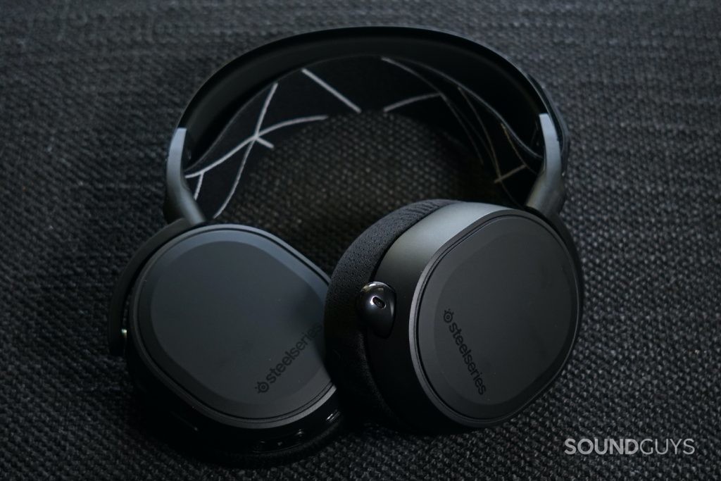 The SteelSeries Arctis 9 gaming headset lays on a fabric surface