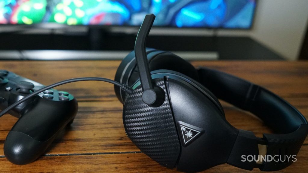 The Turtle Beach Recon 200 gaming headset in black on top of a wood desk.