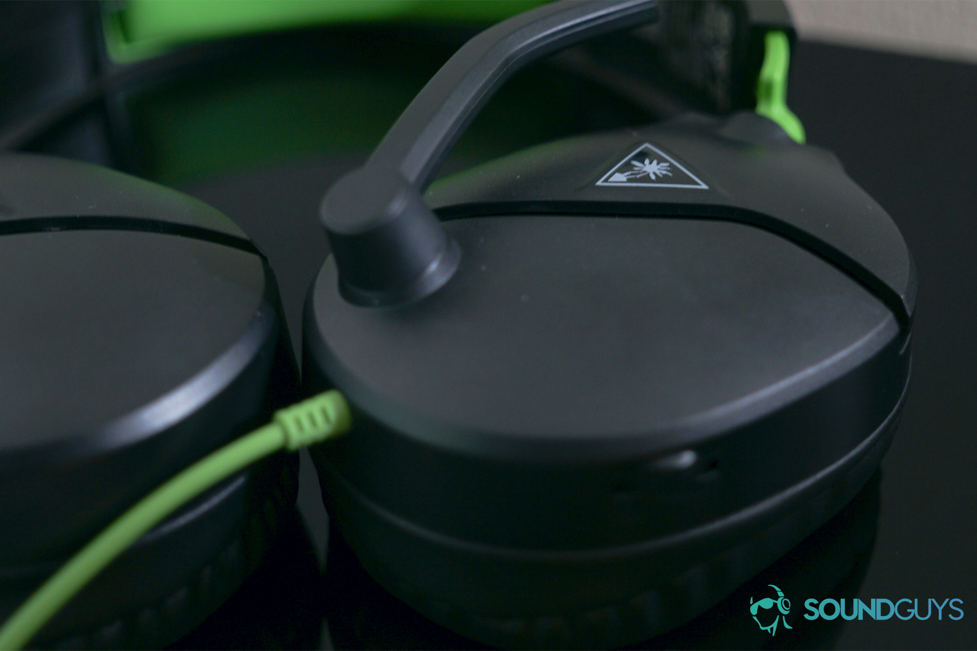 The Turtle Beach Recon 70 gaming headset lays on a black surface with its volume dial and microphone in focus.