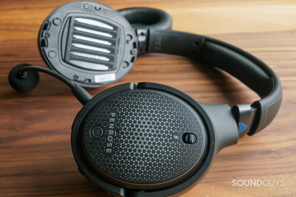 The Audeze Penrose sits on a wooden table with its planar magnetic drivers in view.