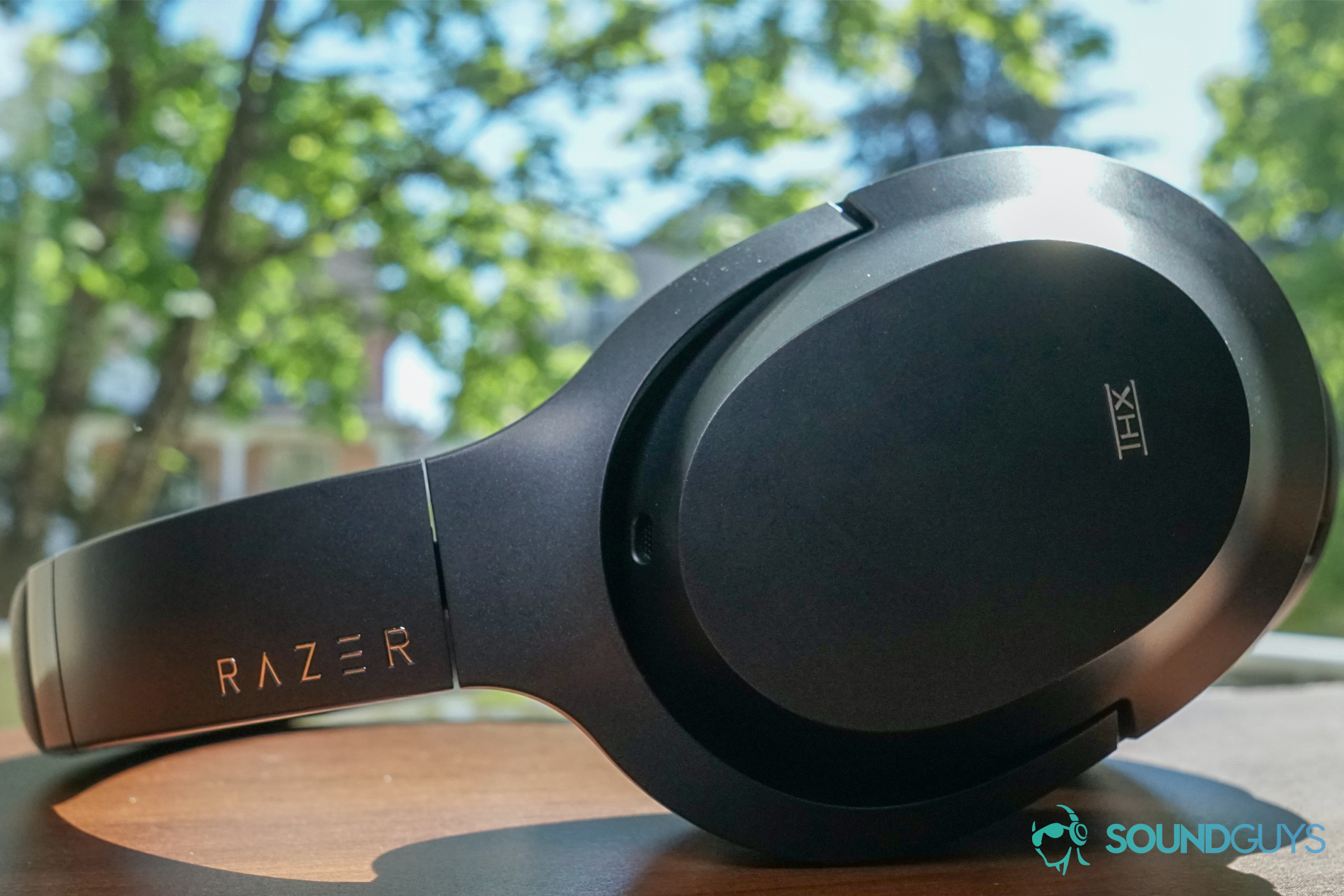 The Razer Opus lays on a wooden table by a window in the sun.