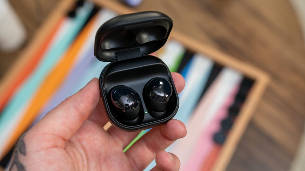 A man holds the open charging case of the Samsung Galaxy Buds Pro in black.
