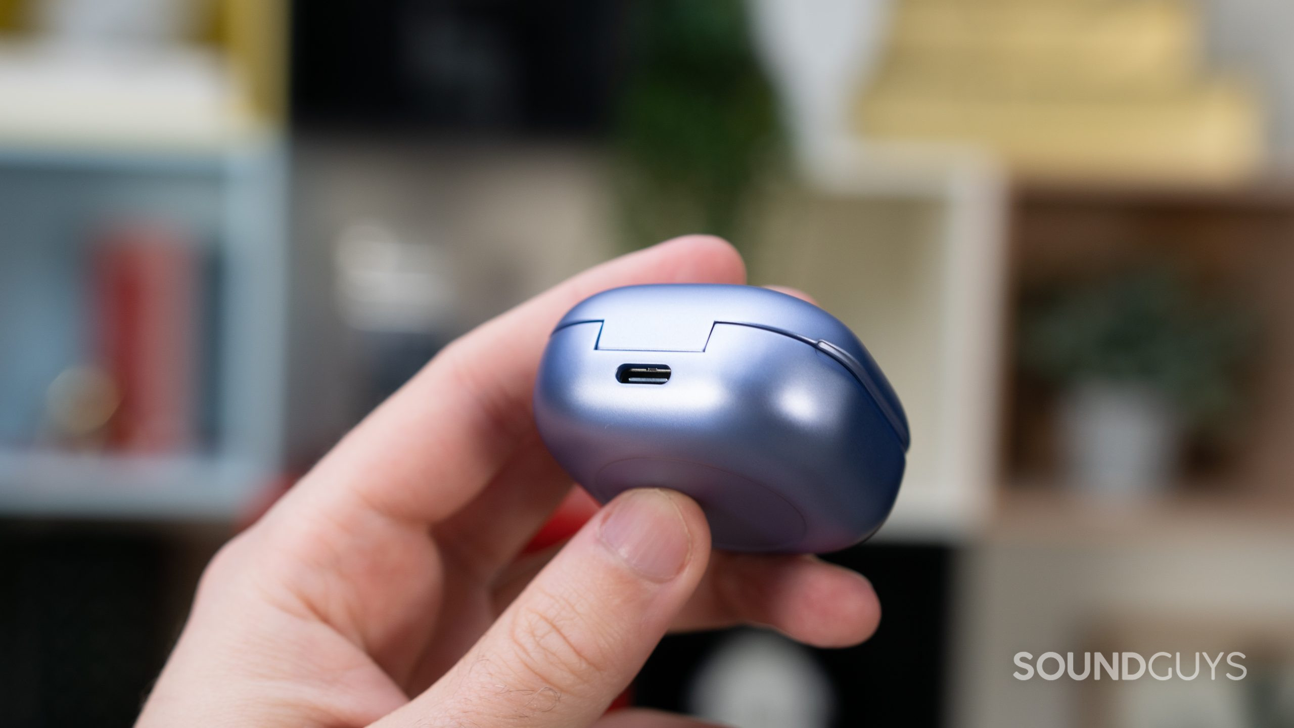 Man holding violet charging case with USB-C input in focus.