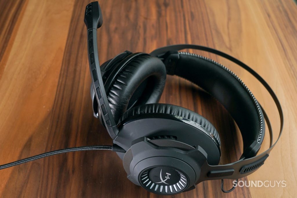 The HyperX Cloud Revolver + 7.1 lays on wooden table.