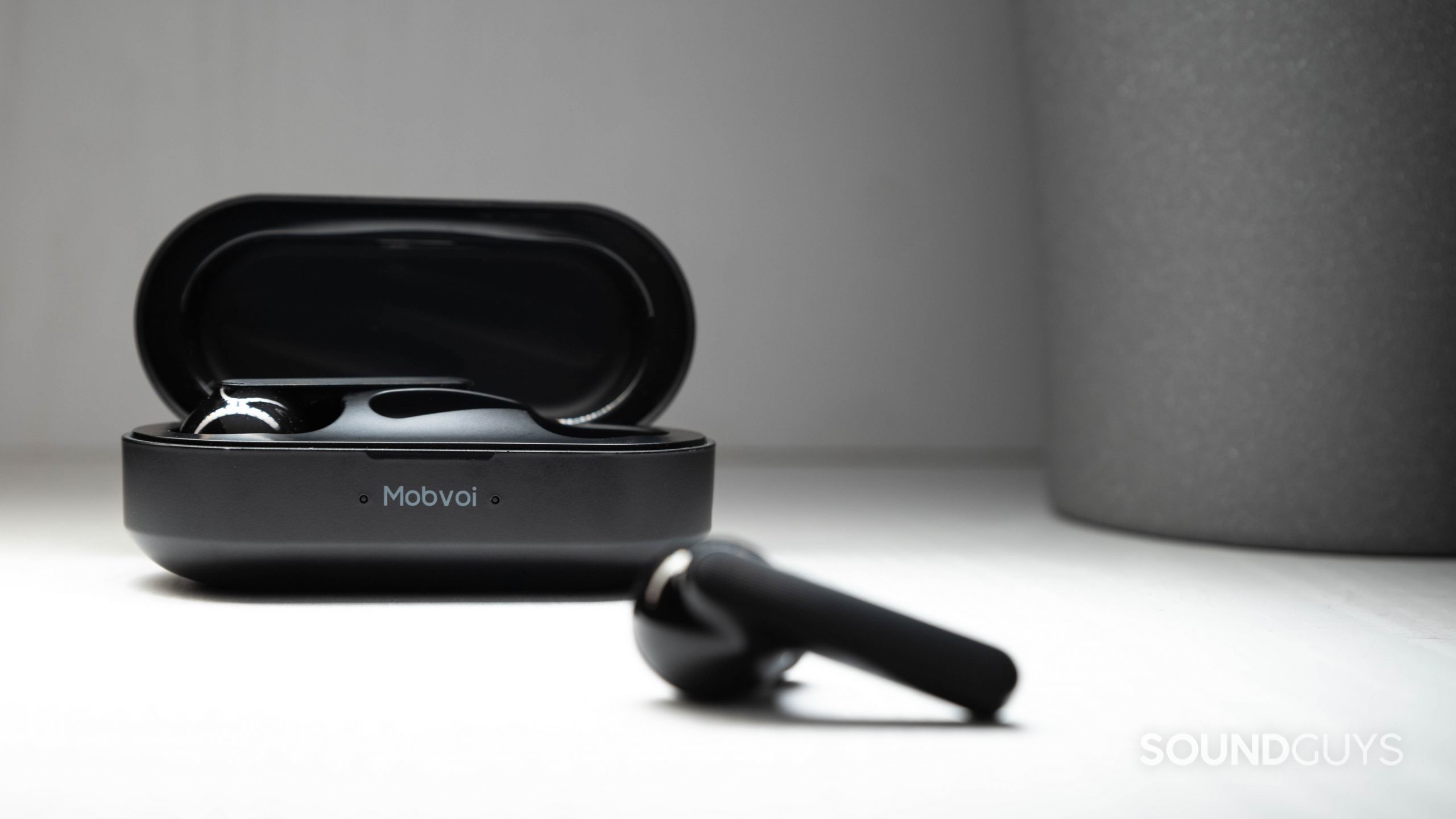 The Mobvoi Earbuds Gesture true wireless earbuds in black, with one earbud outside of the open case and the other inside of it.
