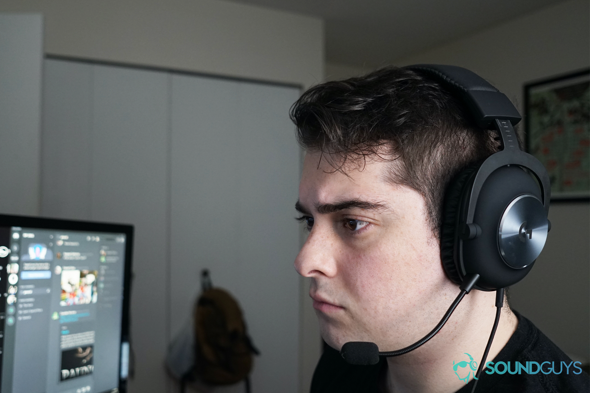 A man wears the Logitech G Pro X gaming headset sitting at a computer, with Discord running on a monitor behind him.